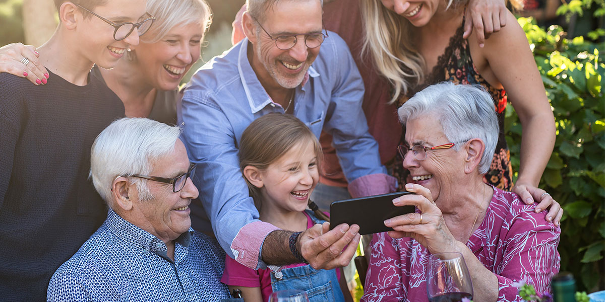 multi-generation family taking selfies on iphone